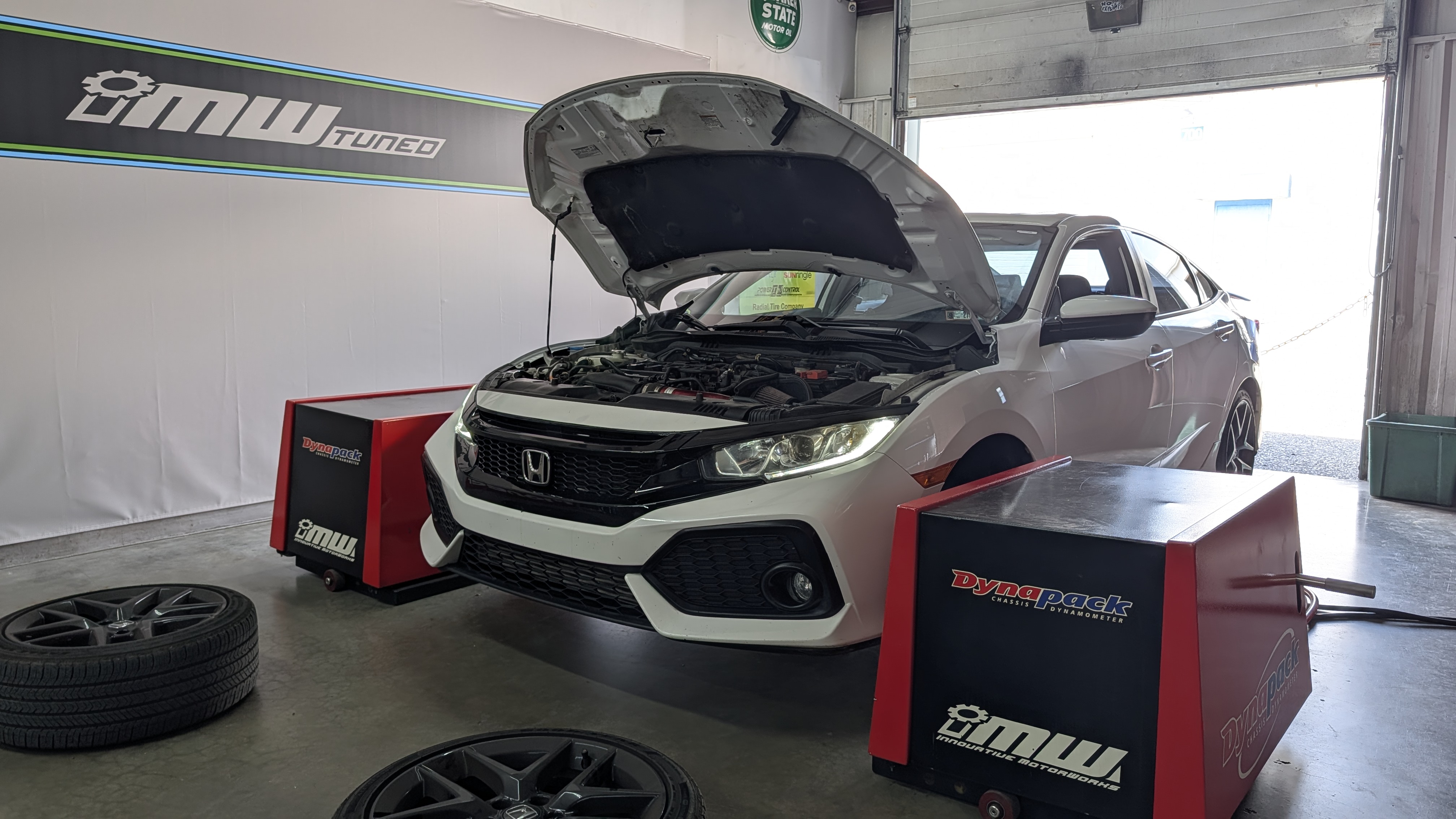 Honda Civic connected to the DynaPack dynamometer inside the IMW shop